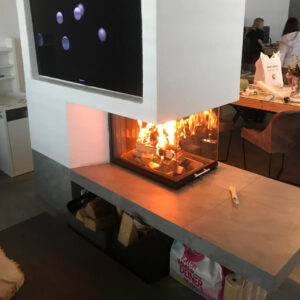 Eine von Sampl gebauter moderner Kamin Ofen mit sichtbarem Feuer und Fliesen