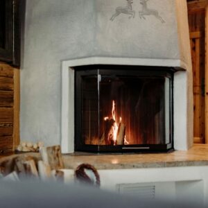 Ein von Sampl gebauter moderner Kachelofen im Chalet Auszeit in einem Hotelzimmer